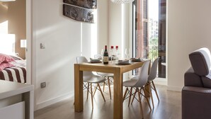 Ein Essbereich mit einem Holztisch, weißen Stühlen und einer Chandelier.