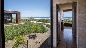 A modern wooden interior with a view of a coastal landscape. - Playa Lobos Casas & Clubhouse (Pichilemu)