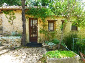 A stone building with a wooden door, windows, and a stone pathway leading to the entrance. - Rental Mazet stone between Nimes and Montpellier (Souvignargues)