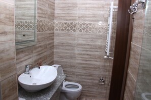 A bathroom with a sink, toilet, and shower area. - Hotel Makona (Tbilisi)