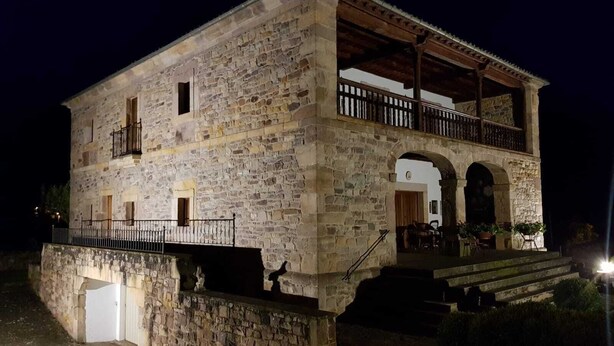 Ein Gebäude aus Stein mit Balkon und überdachter Veranda.