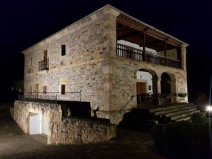 Un edificio de piedra con balcón y porche cubierto.