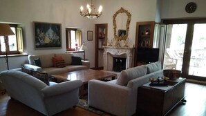 Ein Wohnzimmer mit Kamin, einer Sofagarnitur, einem Couchtisch und einem Fernseher.