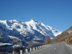 Drive through serene mountain landscapes along a well-maintained road.
