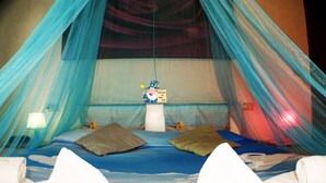 Un llit amb dosser, coixins i una decoració amb forma d'estrella de mar.