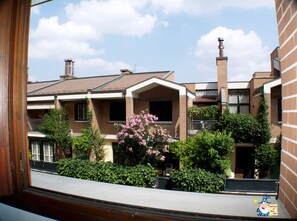 A residential building with a brick facade, multiple windows, and a chimney. - Mago Zurli '- Refined three-room apartment in Bologna with private garage (Bologna)