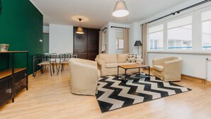 A modern living room with a sofa, chairs, a coffee table, and a large window. - ShortStayPoland Krochmalna - B39 (Warsaw)
