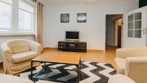 A modern living room with a sofa, a coffee table, and a TV on a stand. - ShortStayPoland Krochmalna - B39 (Warsaw)