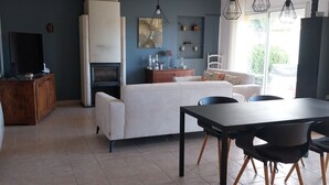 Un espace de vie moderne comprenant un coin repas, une cuisine et un coin salon.