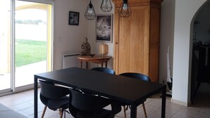 Un coin repas avec une table et des chaises, un buffet en bois et une statue de Bouddha.