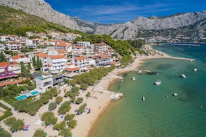 A coastal town with buildings, a beach, and boats. - Apartment Bakota with panoramic sea view, only 200m from the sea (Duće)