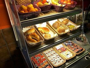 A display case with various food items including fruits, bread, and packaged goods.