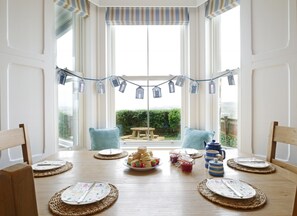 Enjoy meals in this dining area with a bay window offering a garden view.
