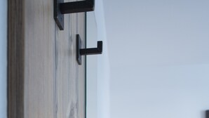 Un interior moderno con una pared de madera, una mesa de comedor con sillas y dos lámparas fijadas a la pared.