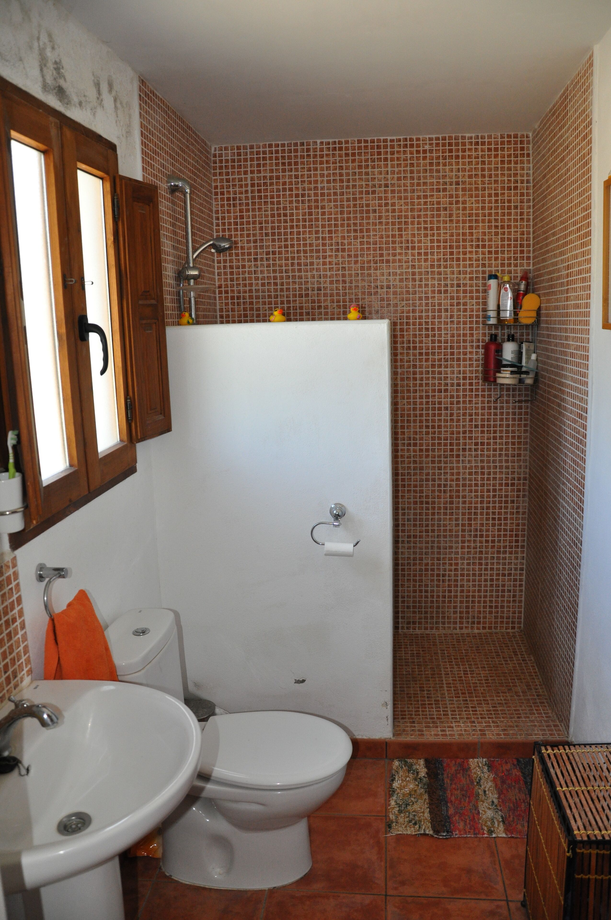 A bathroom with a toilet, sink, and shower.
