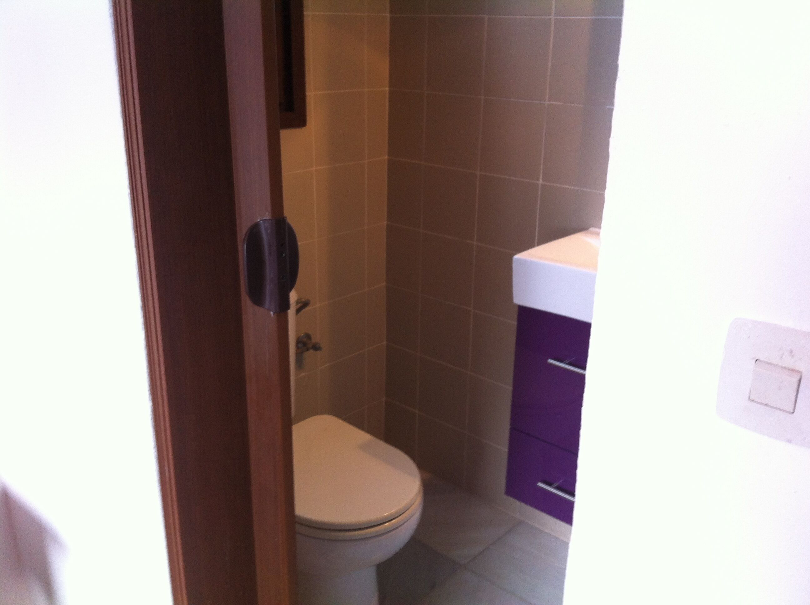 Ein kleines Badezimmer mit Toilette, Waschbecken und einem Schrank.