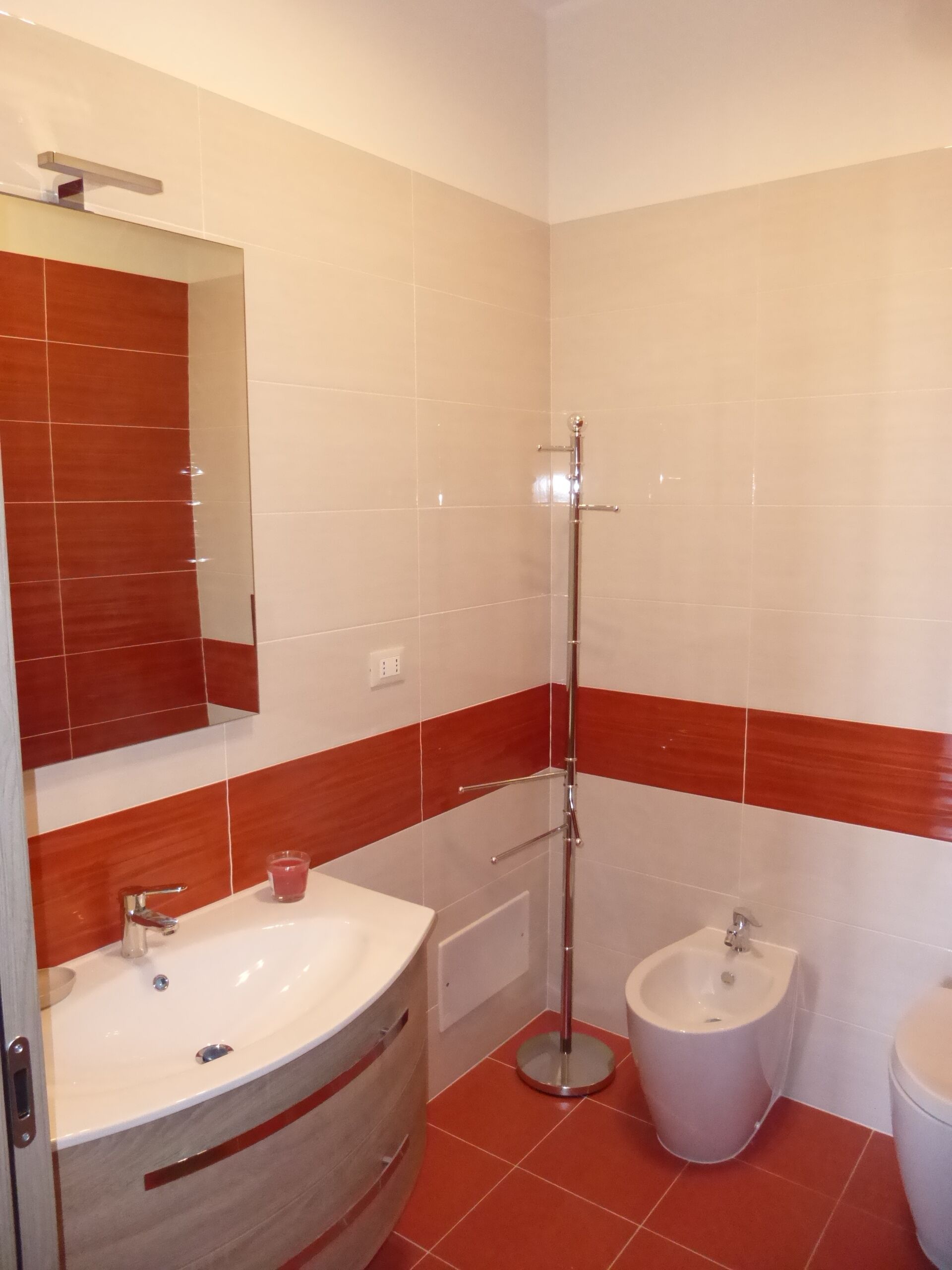 A bathroom with a white sink, a bidet, and a mirror.