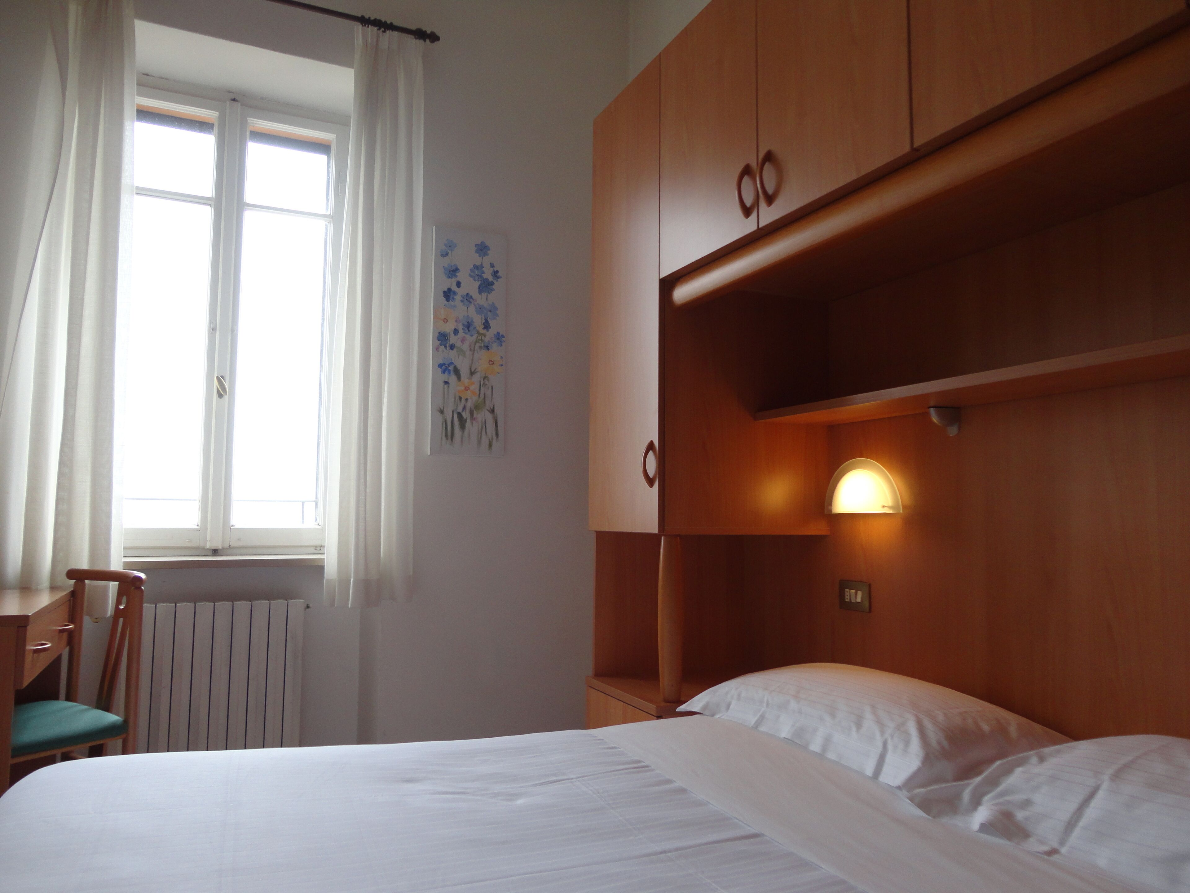Un dormitorio con una cama, un escritorio y un radiador.