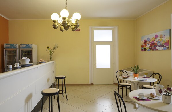 A kitchen with a white refrigerator, a sink, and a dining area with a table and chairs.