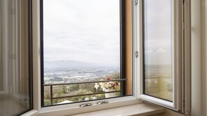 A window with a view of a cityscape, a radiator below, and a balcony railing. - Hotel Sacro Cuore (Perugia)
