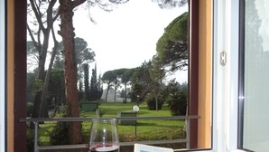 A window with a glass of red wine and a postcard on a table. - Hotel Sacro Cuore (Perugia)