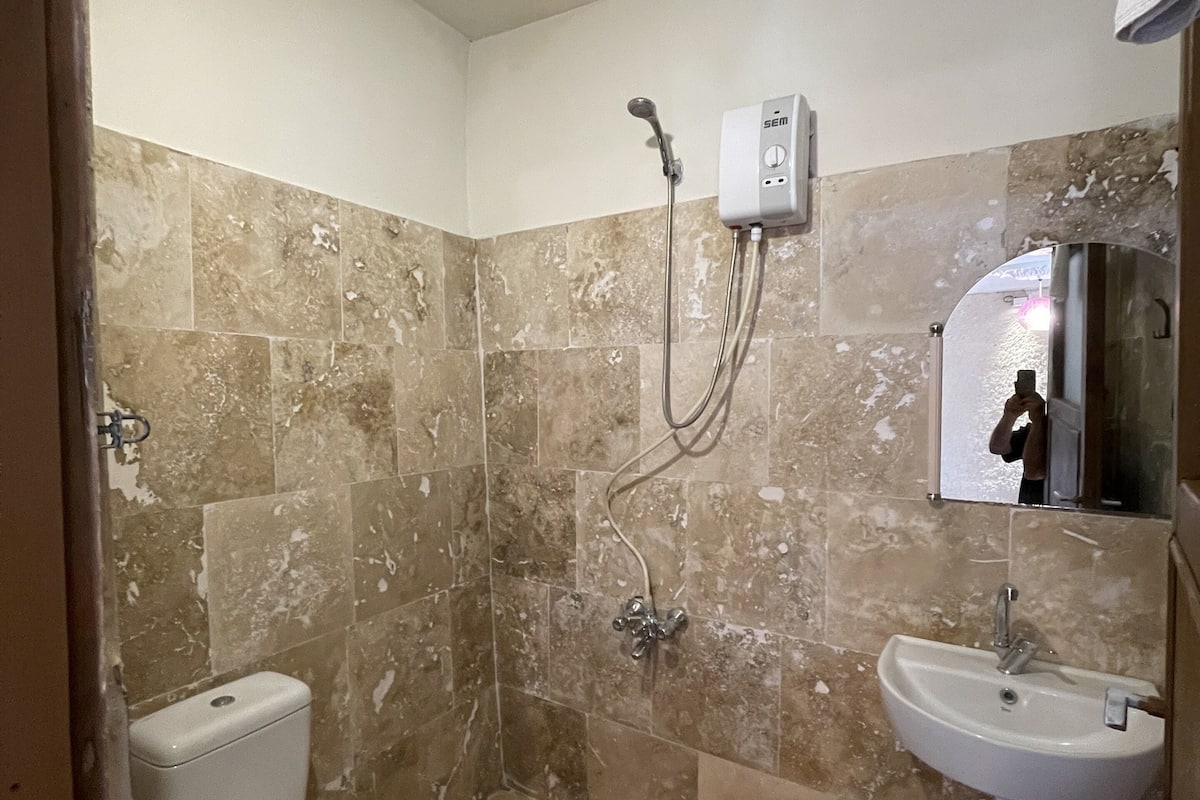 Un baño con inodoro, ducha y lavabo.