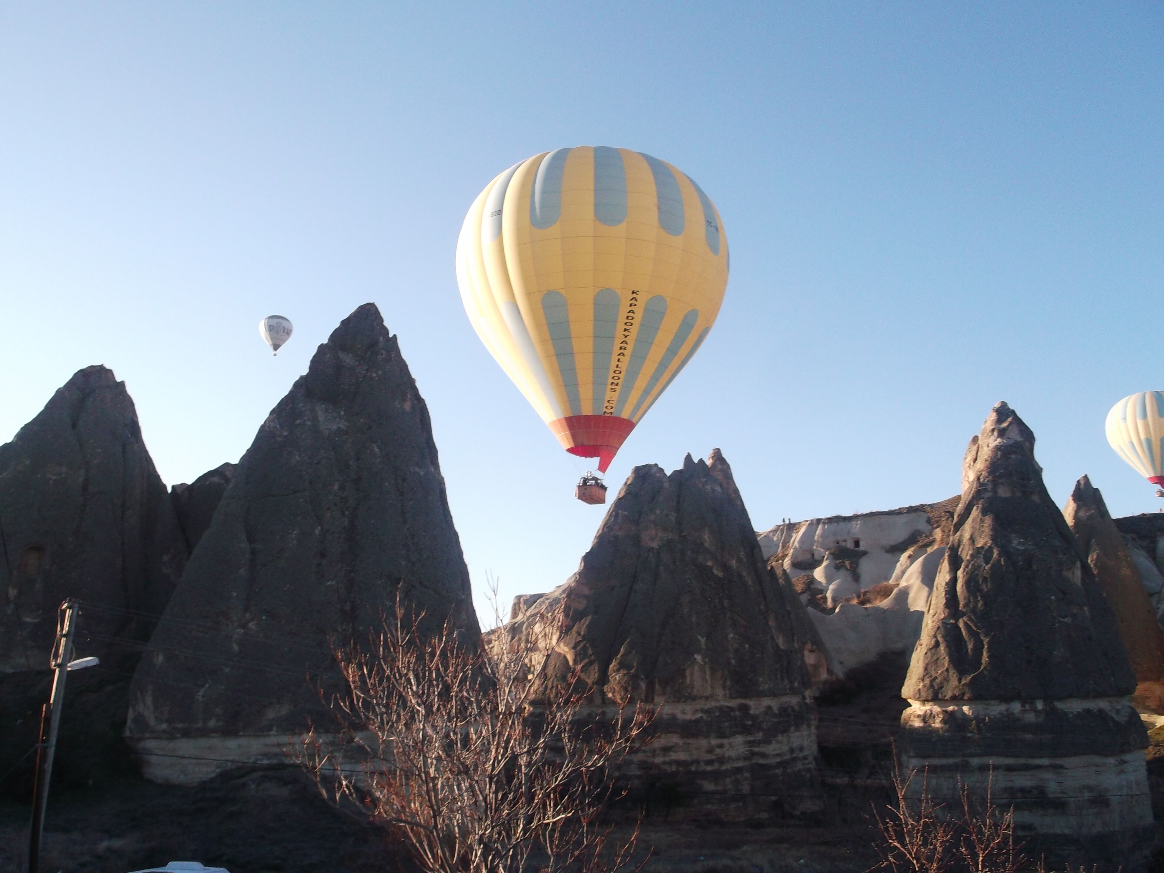 A hot air balloon flying over rocky formations.