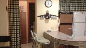 A dining area with a checkered tablecloth, a brown handbag, and a remote control on the table. - Villa La Martina (Syracuse)