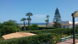 A coastal property with a view of the sea, surrounded by palm trees and a well-maintained garden. - Villa La Martina (Syracuse)