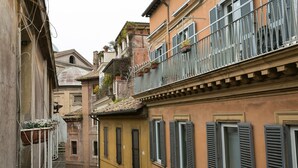 A narrow street with buildings featuring balconies and windows.