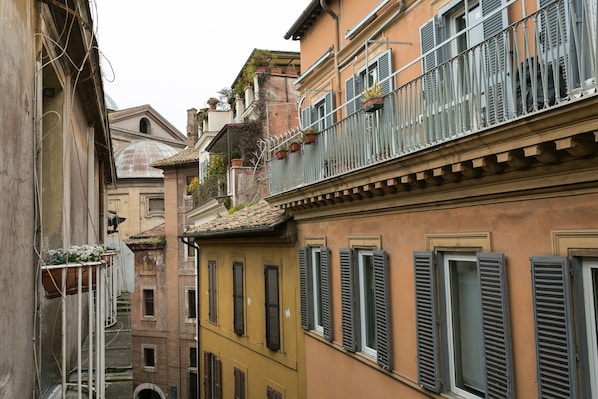 A narrow street with buildings featuring balconies and windows. - Parione House apartment in the center of Rome (Roma)