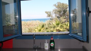 A bathroom with a window view of a coastal landscape, a sink, and a bottle of Fairy dish soap. - Beachside new luxury apartment with sea & mountain views, great location & Wi-FI (Dénia)