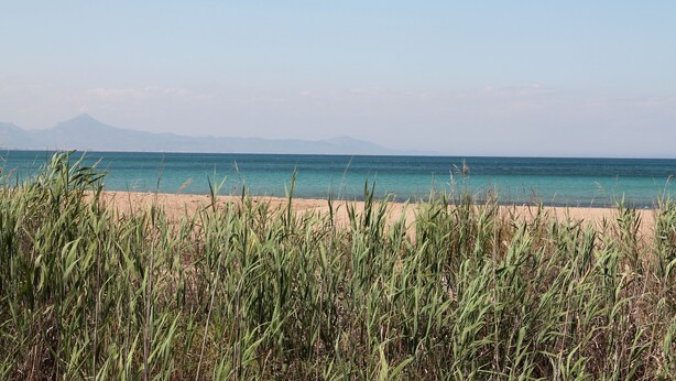 A beach with clear water and distant mountains. - Beachside new luxury apartment with sea & mountain views, great location & Wi-FI (Dénia)