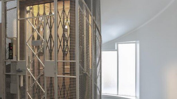 A room with a metal partition, a staircase, and a window. - 2ndhomes Bright Top Floor Studio in Fredrikinkatu (Helsinki)
