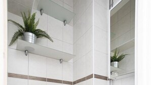 A modern bathroom with a white toilet, a white sink, and a blue bath mat. - 2ndhomes Bright Top Floor Studio in Fredrikinkatu (Helsinki)