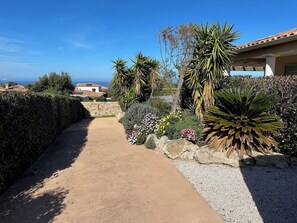 Un chemin menant à un bâtiment d’où l’on a une vue sur l’océan.