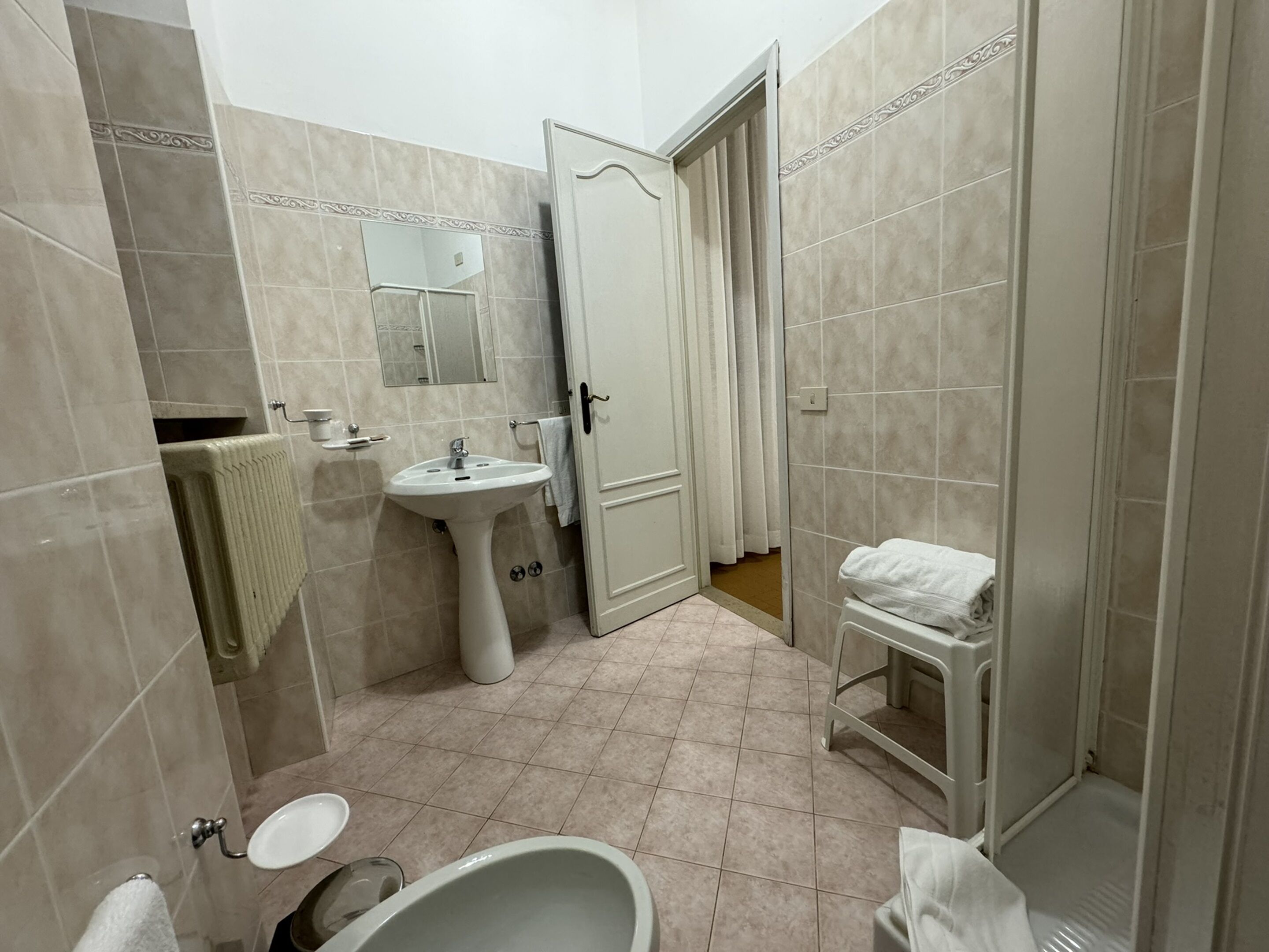 Une salle de bain équipée d’un lavabo, d’un miroir, de toilettes et d’une baignoire.
