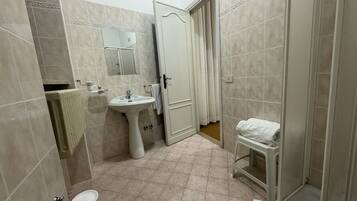 Une salle de bain équipée d’un lavabo, d’un miroir, de toilettes et d’une baignoire.