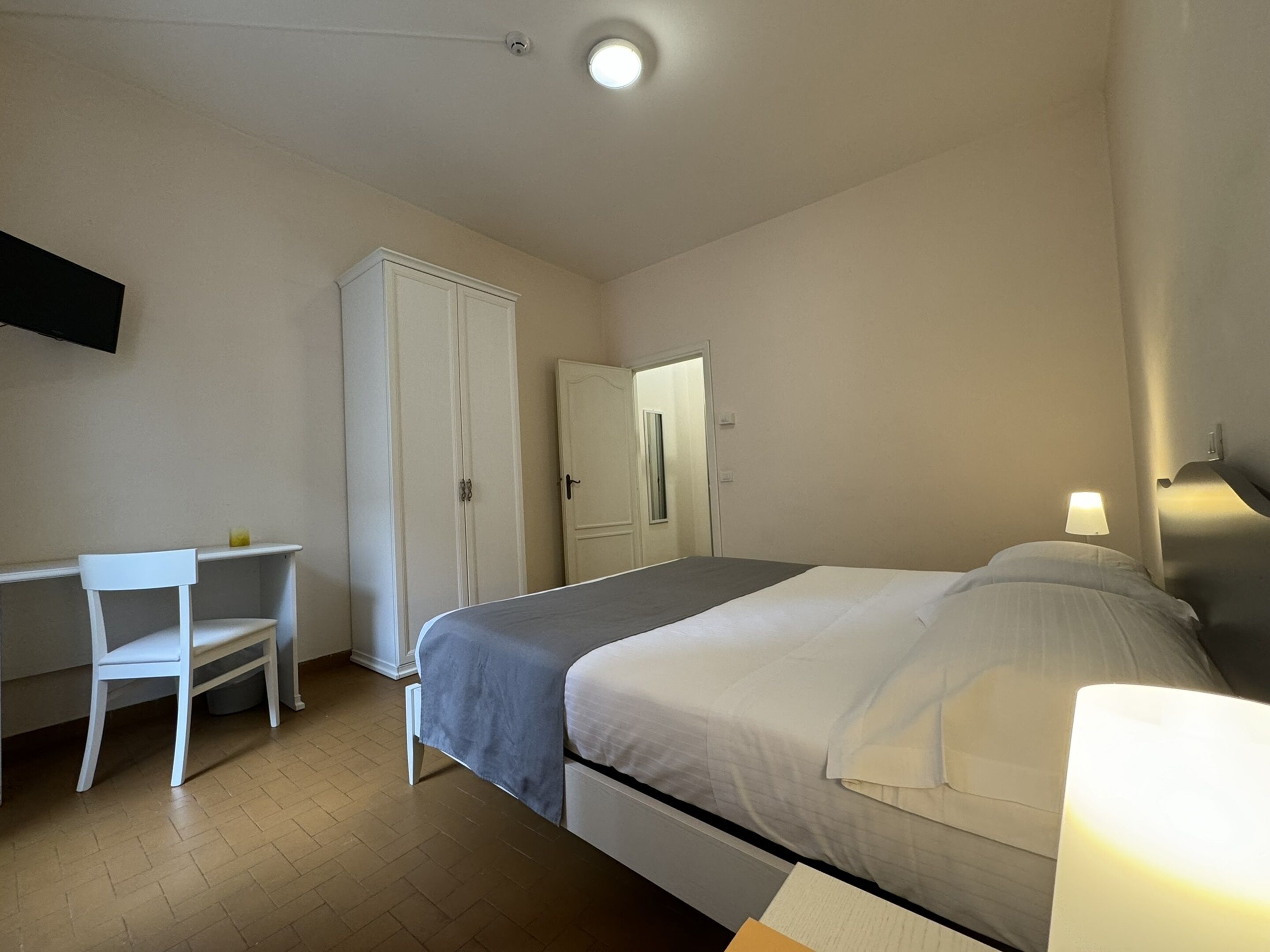 Un dormitorio con cama, escritorio y armario.