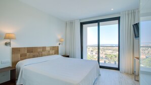 Une chambre d’hôtel avec un grand lit, une table de chevet, une lampe et un téléviseur.