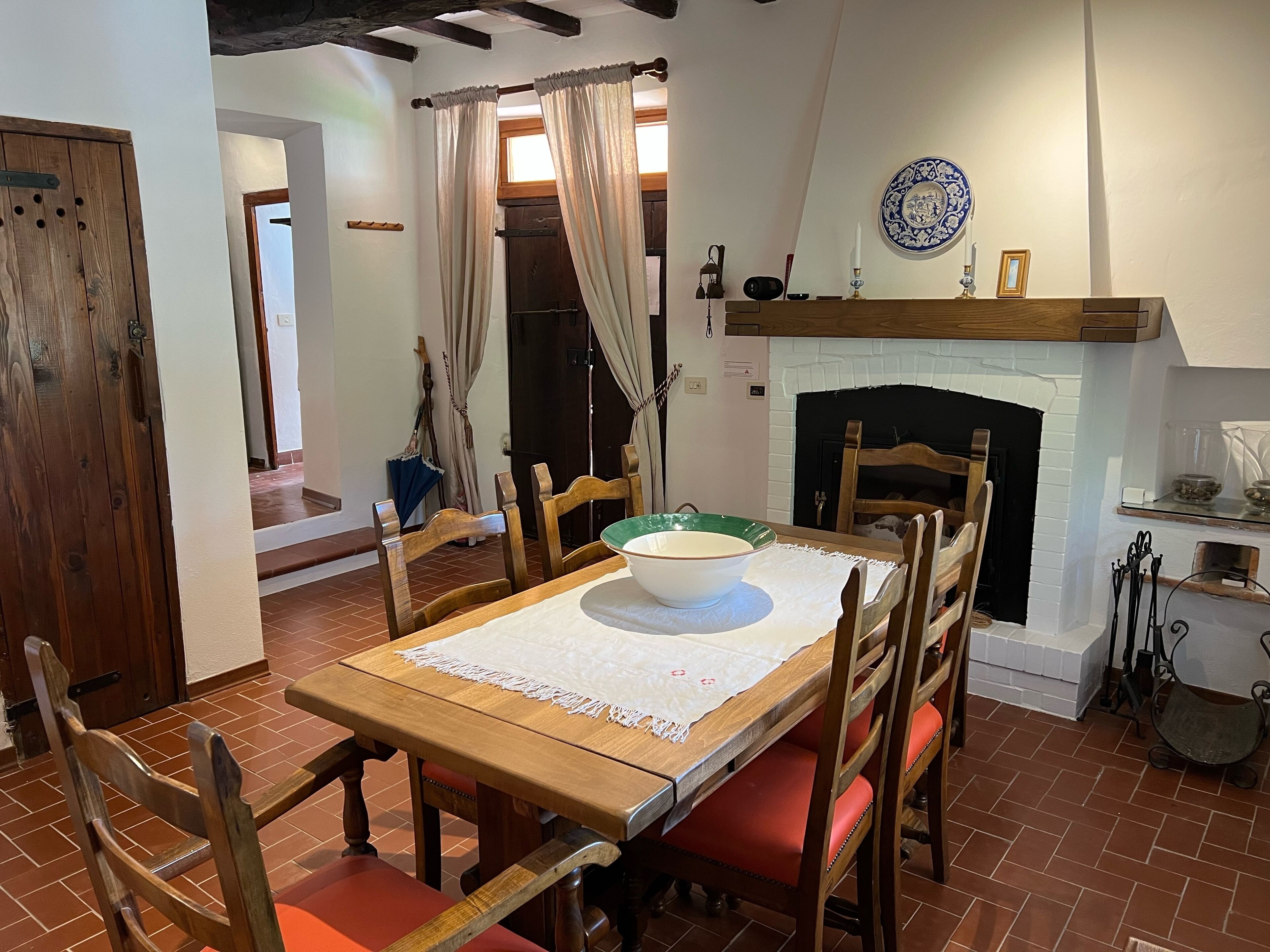 A dining area with a wooden table, chairs, and a fireplace.