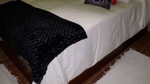 A bed with white bedding, black and red pillows, and a black throw blanket. - Very cozy stone house (Breña Alta)
