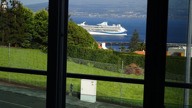 A cruise ship docked at a port with a mountainous backdrop. - Luxury  Repouso do Milhafre 181/AL (Horta)