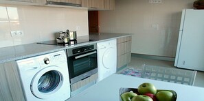 Una cocina moderna con lavadora, horno y refrigerador.