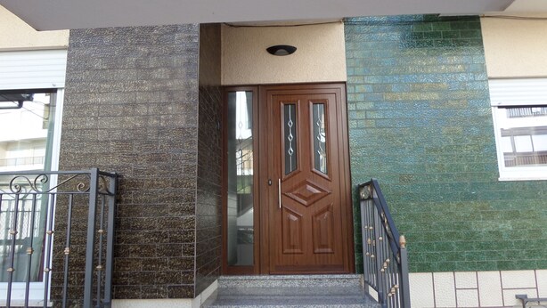 A building entrance with a wooden door, steps, and a metal railing. - Rental House 12Om² - 8 people - Figueira da Foz (Buarcos)
