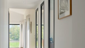 A corridor with glass doors leading to a balcony, wooden flooring, and a framed picture on the wall. - Luxury Provencal Farmhouse with aircon, Pool, WiFI  -  Vaison/Malaucene area. (Malaucène)