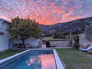 A swimming pool with a stone wall and a tree in a backyard. - Luxury Provencal Farmhouse with aircon, Pool, WiFI  -  Vaison/Malaucene area. (Malaucène)