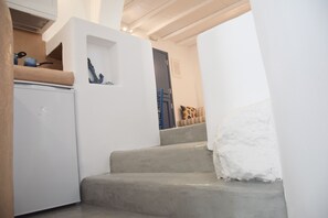 Eine Treppe mit einer weißen Wand und einem grauen Boden, die zu einer Tür führt.