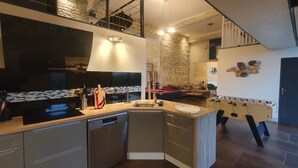 A modern kitchen with a built-in stove, a dishwasher, and a foosball table. - Domaine de La Retardière ****, heated swimming pool (Sepmes)