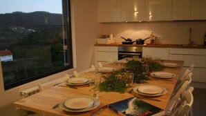 Une table à manger est dressée pour six personnes, avec des assiettes, des verres et des couverts. Un livre intitulé « EUROPE » est posé sur la table.